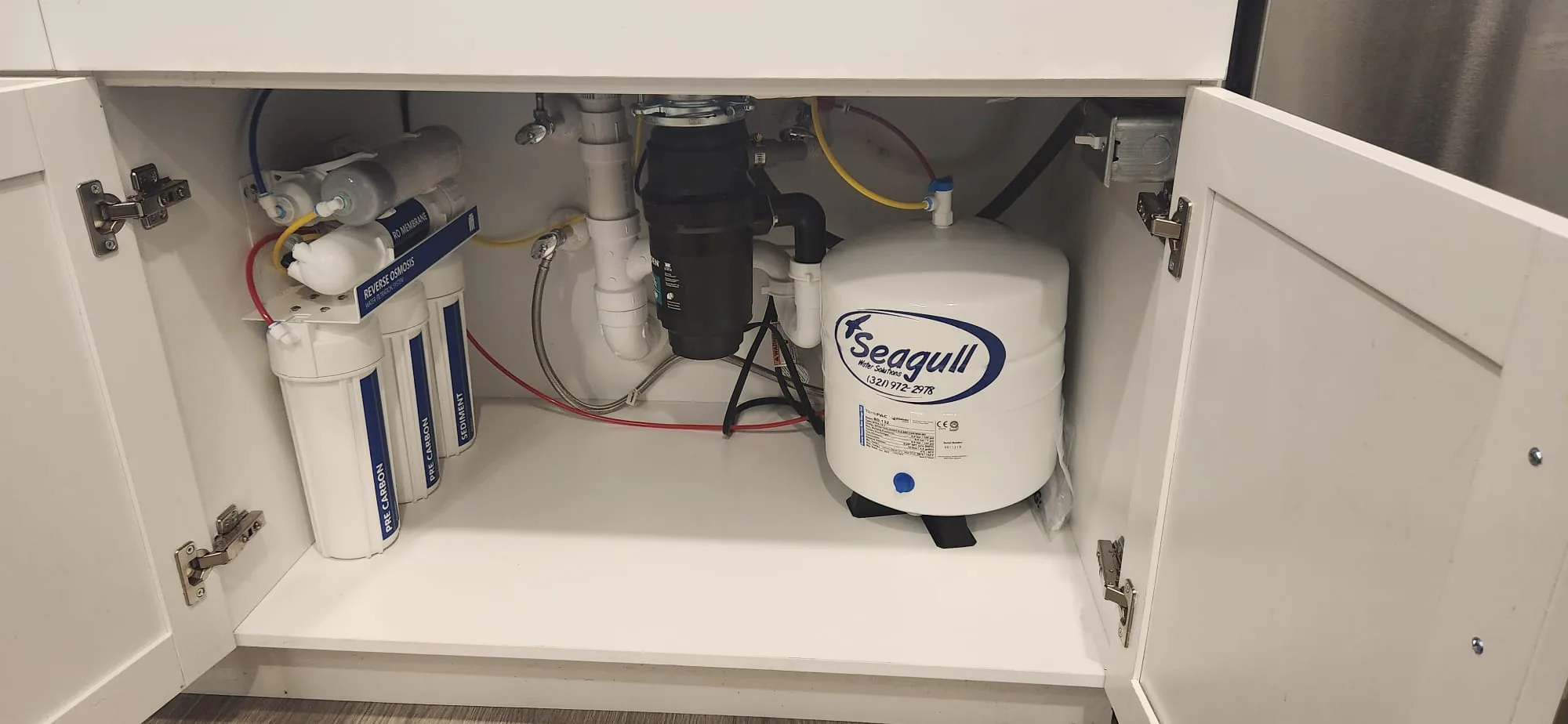 Alkaline reverse osmosis drinking water system under a kitchen sink, installed by Seagull Water Solutions in Orlando, FL